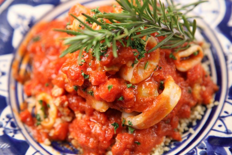 Delicious Italian-style seafood dish topped with fresh herbs and savory tomato sauce.