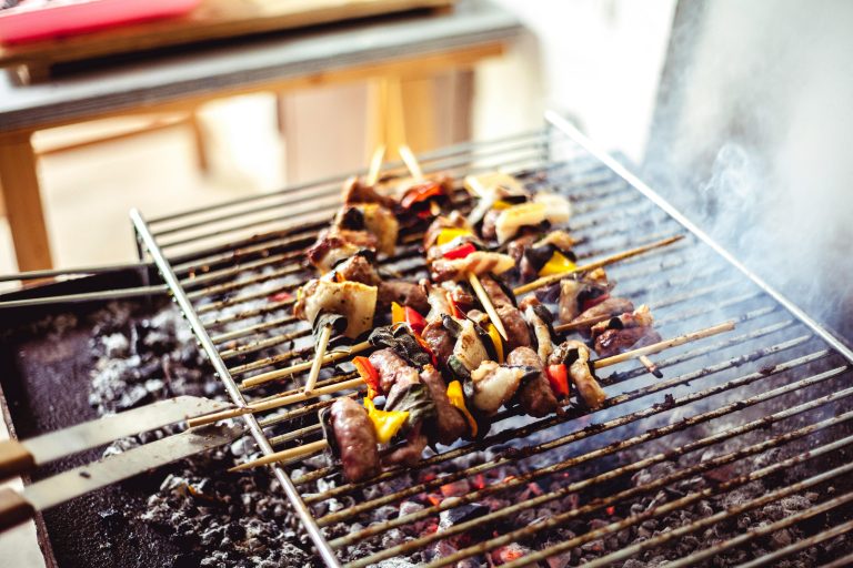 Savory grilled skewers with meat and vegetables sizzling over hot charcoal, perfect for outdoor cooking.